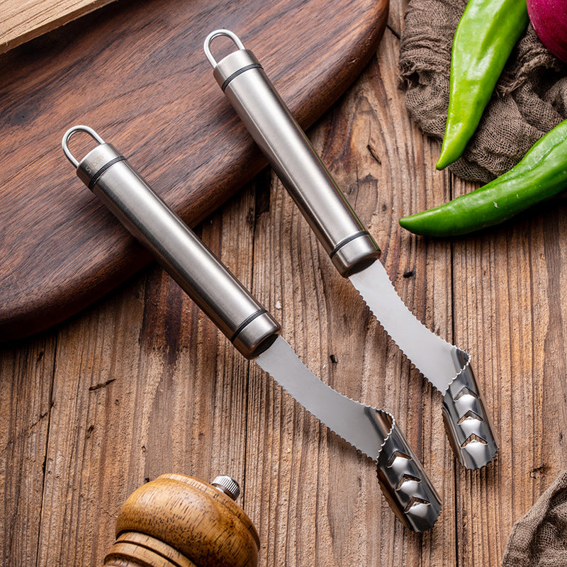 Two metal kitchen utensils on a wooden surface with vegetables in the background