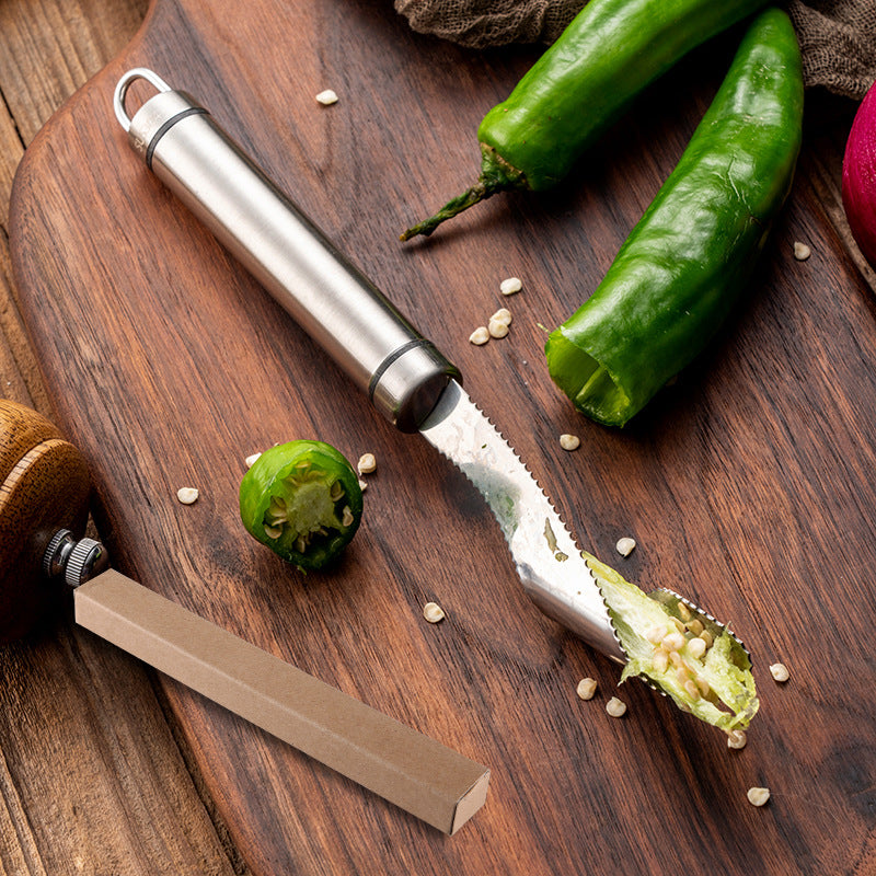Chilly being sliced with a knife on a wooden cutting board.